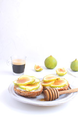 Fresh green figs sandwiches canapes Grey rustic plate Black coffee Espresso Wholegrain bread Goat cheese Healthy eating concept Appetizer Isolated Copy space White background