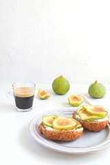 Fresh green figs sandwiches canapes Grey rustic plate Black coffee Espresso Wholegrain bread Goat cheese Healthy eating concept Appetizer Isolated Copy space White background