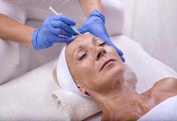 Obraz na płótnie Canvas Senior woman during skin treatment in beauty salon