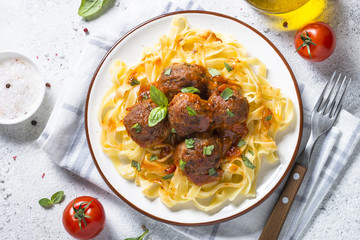 Meatballs in tomato sauce with pasta tagliatelle top view.