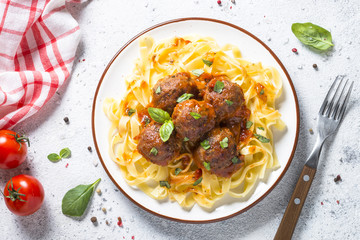 Meatballs in tomato sauce with pasta tagliatelle top view.
