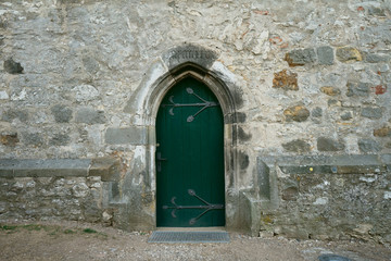 Fototapeta na wymiar Alte grüne Seitentür an einer Kapelle