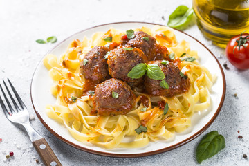 Meatballs in tomato sauce with pasta tagliatelle top view.