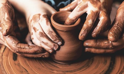 Hands of potter making clay pot, closeup photo