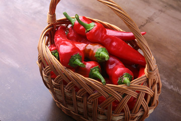 Wicker basket full of fresh red chili peppers.