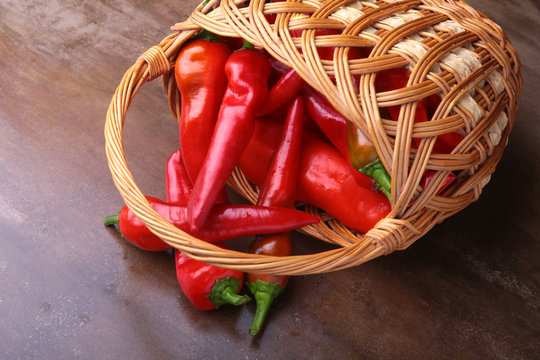 Wicker basket full of fresh red chili peppers.