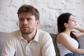 Upset millennial man think about relationship problems, having fight with proud female lover, offended couple not talking after family quarrel, sad male consider breaking up or divorce with girlfriend