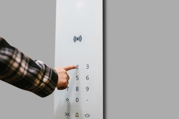 Close-up of a girl pressing a touch button in a modern elevator.