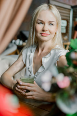 Portrait of beautiful blonde with blue eyes chilling at restaurant