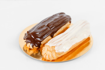 Traditional french eclairs with chocolate. Group of french dessert Eclair on white background. custard pastry dessert with whipped cream inside