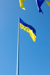 Ukrainian flag. Yellow blue Ukrainian flag on the background of the sky. Ukraine's Independence Day. National symbol in the rays of the sun