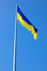 Ukrainian flag. Yellow blue Ukrainian flag on the background of the sky. Ukraine's Independence Day. National symbol in the rays of the sun
