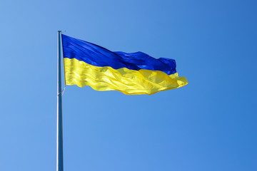 Ukrainian flag. Yellow blue Ukrainian flag on the background of the sky. Ukraine's Independence Day. National symbol in the rays of the sun
