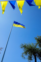 Ukrainian flag. Yellow blue Ukrainian flag on the background of the sky. Ukraine's Independence Day. National symbol in the rays of the sun