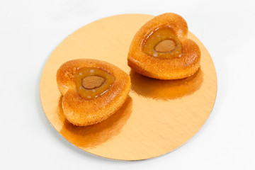 Nuts cake heart-shaped. Piece of Cake with almond ant peanut on a Plate. Sweet food. Sweet dessert. Food background. Close up.