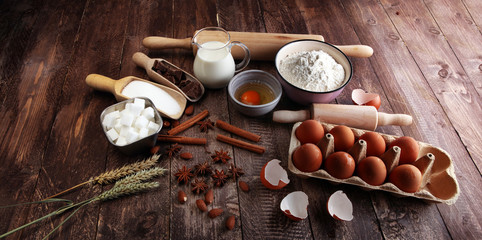 Bakery ingredients - flour, eggs, butter, sugar, yolk, almond nuts on blue table. Sweet pastry baking concept.