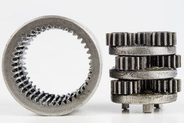 Planetary gear from a small device on a bright table. Gear wheels from a specialist device.