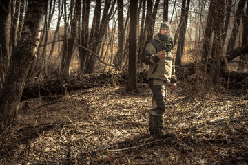 Hunter man autumn forest with transmitter during hunting season  