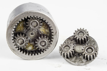 Planetary gear from a small device on a bright table. Gear wheels from a specialist device.