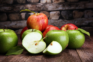 Ripe red apples and green apple on wooden background