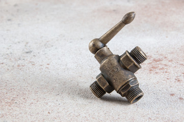 Antique bronze water tap adapter on concrete background.