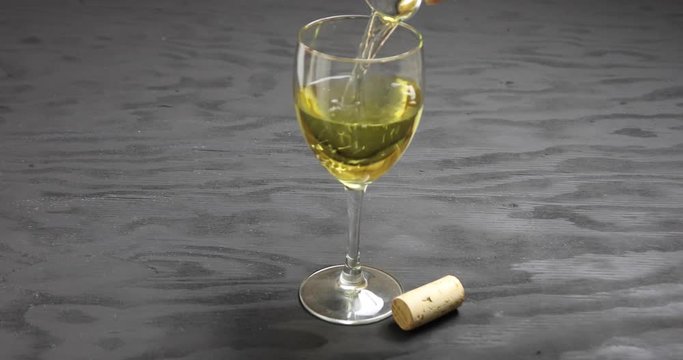 Close up of white wine pouring into glass