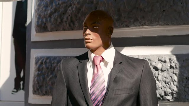 Weird afro businessman dummy wears suit. With batman shadow on his face