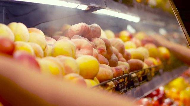 Peaches, kiwi, tomatoes and other vegetables and fruits are cooled on the shelf. Close up