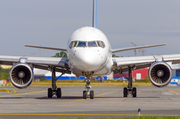 Airplane taxiing on the apron of the airport on the asphalt is visible marking.