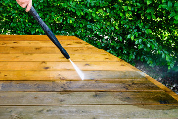 cleaning terrace with a power washer - high water pressure cleaner on wooden terrace surface - 220013723