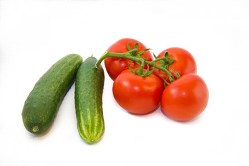 Tomatoes on a branch and cucumbers isolated on white background. Vegetables on a white background. Food . Healthy eating.
