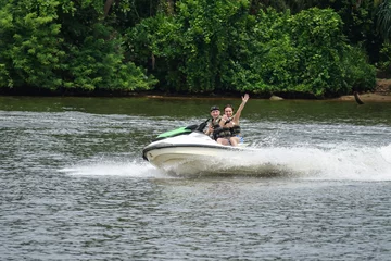 Fotobehang Happy young couple with thumbs up enjoying and having fun riding on a jet ski. Tropical coast of Sri Lanka © Goldream