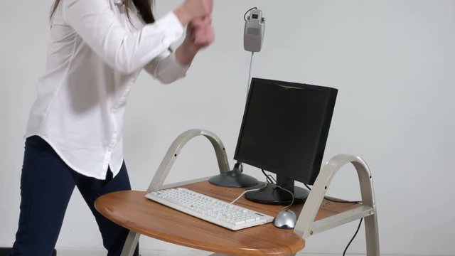 Crazy woman office worker destroying computer with sledge hammer
