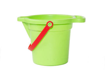 A child's green sand bucket is isolated on white background. Children's games.