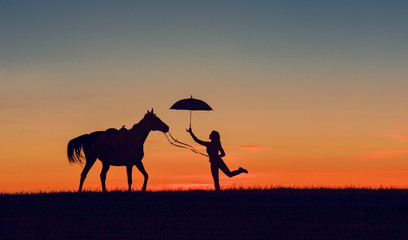Idyllic friendship scene with horse silhouette, horsemanship concept. Horse and girl with open umbrella on romantic sunset. 