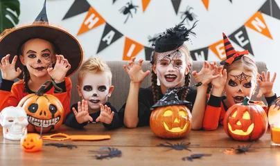 Foto op Plexiglas happy Halloween! a group of children in suits and with pumpkins in home © JenkoAtaman