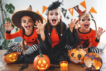 happy Halloween! a group of children in suits and with pumpkins in home