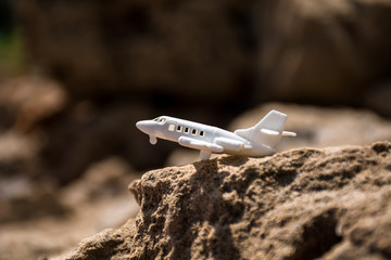 White toy plane standing on yellow cliff.