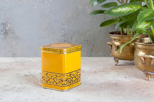 Vintage tea tin box on concrete background.