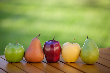 Apples and Pears lined up in a row on table