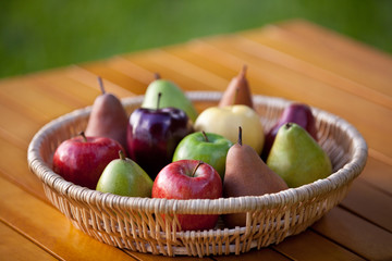 A basket of fruit with apples and pears