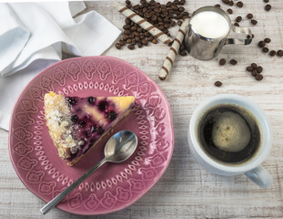 Dessert of blueberries and cottage cheese on a wooden light background with coffee. Summer fruit dessert. View from above.