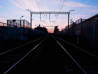 Fototapeta na wymiar Symmetric two railway tracks during sunset background