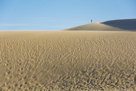 Persona en lo alto de m&eacute;danos de arena, playa de Valizas, Uruguay