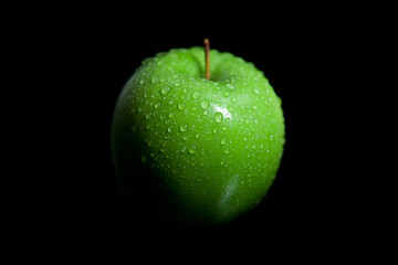 Wet green granny smith apple with black background