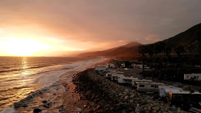 RV park (campground) at coast, California. Ocean. California during sunset. Aerial view, from above, drone flying over water.
