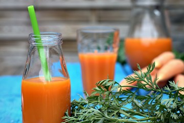 Healthy eating,tasty and vegetable concept-natural homemade carrot juice in glass on an old wooden blue table in the background.