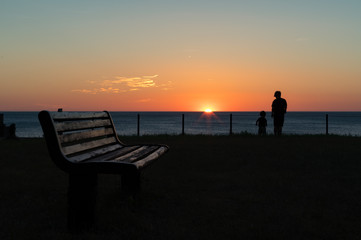 夕暮れの海とベンチ