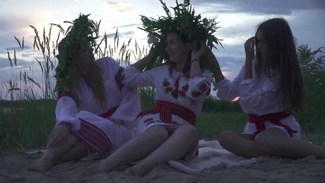 Three young girls in national costumes on the beach