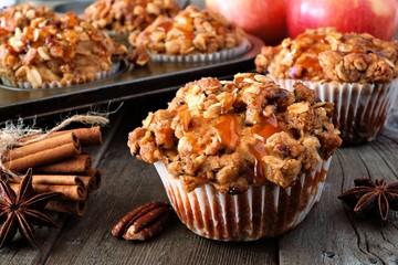 Autumn caramel apple muffins. Close up table scene on a rustic wood background.